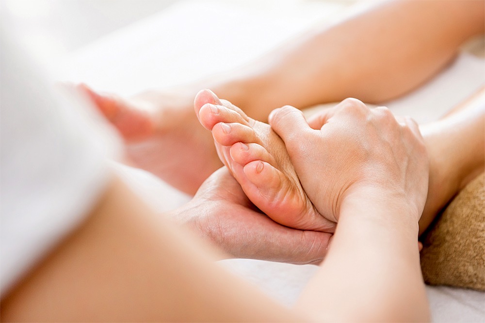 Fußreflexzonenmassage: Fuß liegt zwischen zwei Händen
