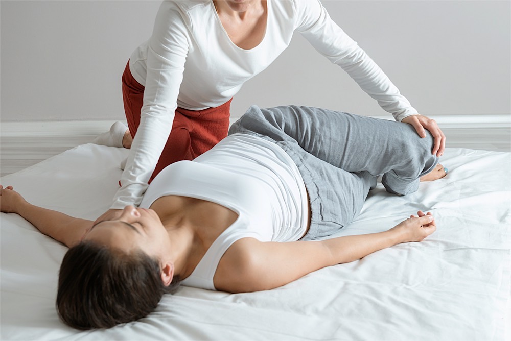 Shiatsu: liegende Drehung der Hüfte bei Frau in Rückenlage